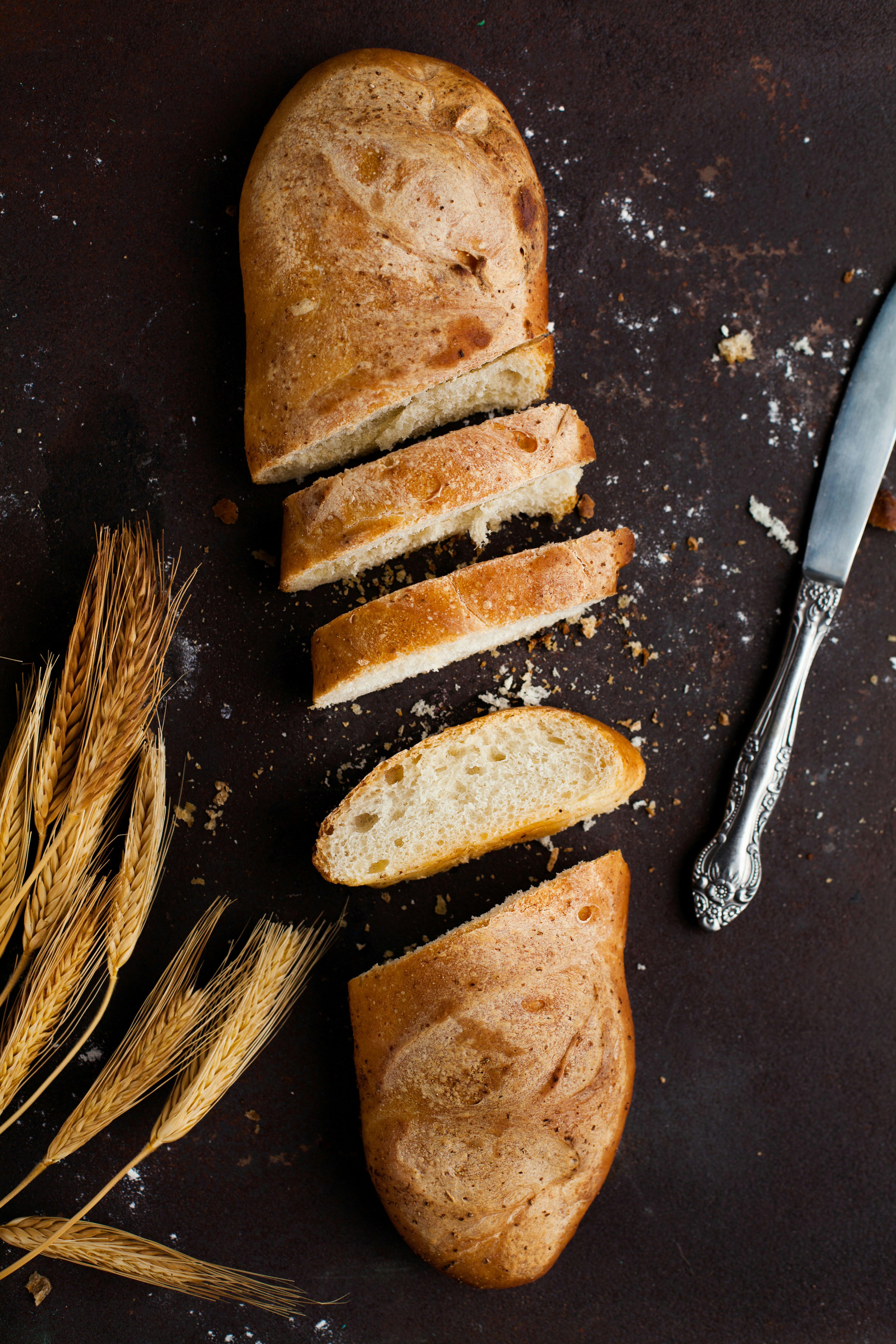 sliced of baked bread beside stainless steel bread knife